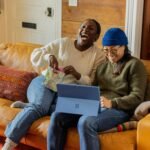 a person sitting on a couch with a laptop